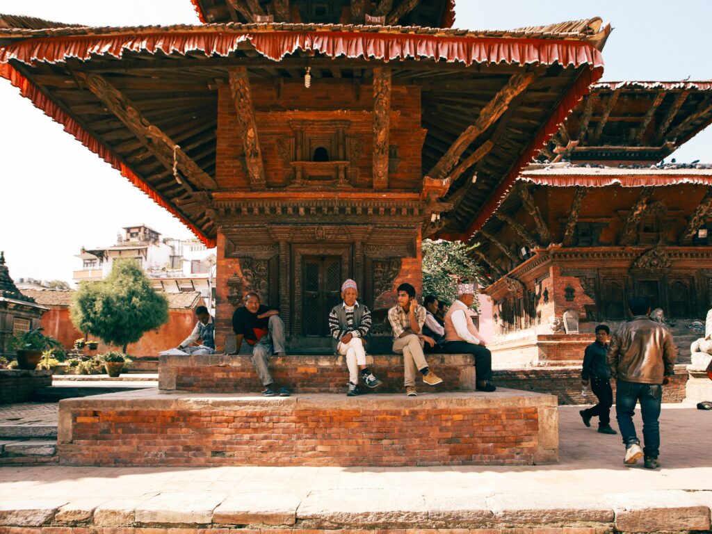 Traditional Nepalese architecture and people gathered in a historic square in Kathmandu, Nepal.